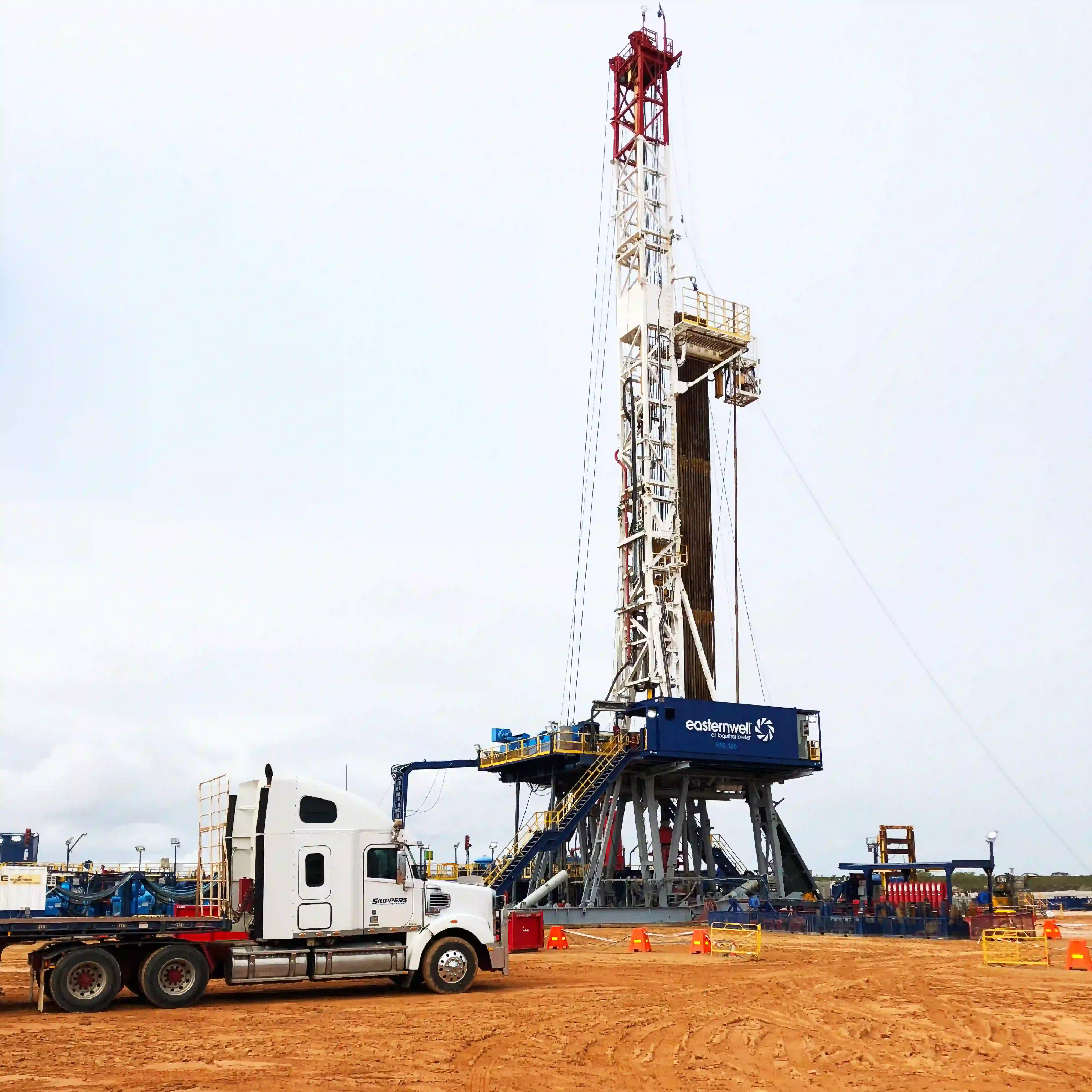 a picture of a truck next to a drilling rig awaiting pickup of mine freight