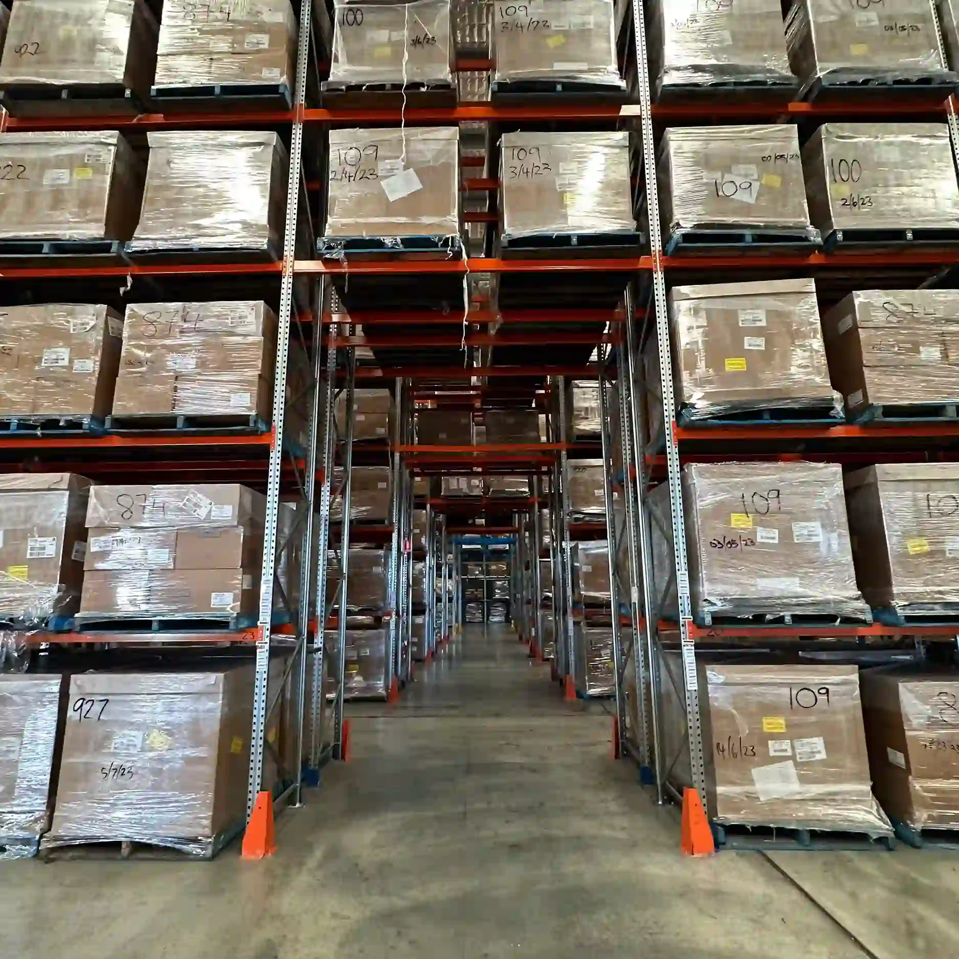 a picture looking down an access lane of a skippers warehouse with alot of racking